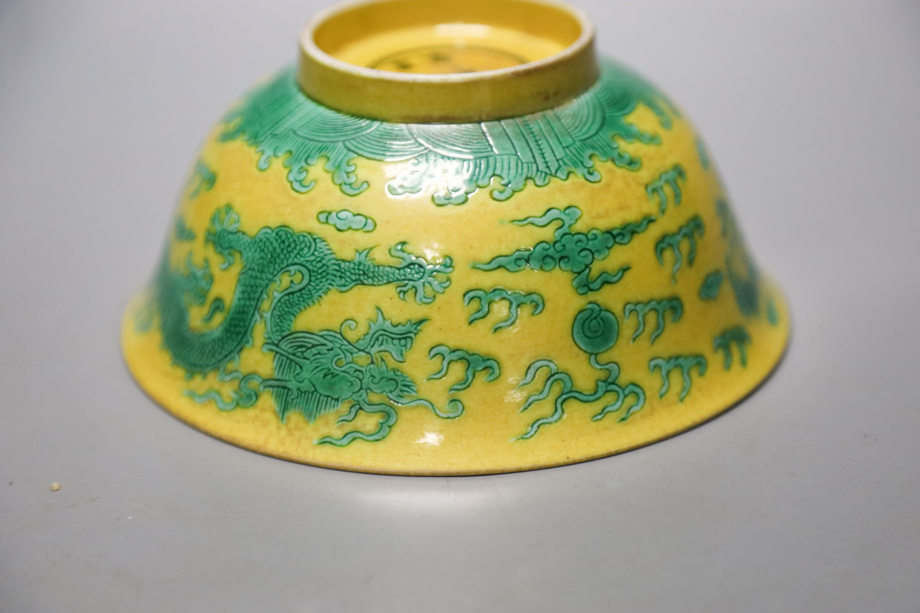 A Chinese yellow ground sgraffito’dragon’ bowl, Kangxi mark but later 15cm diameter